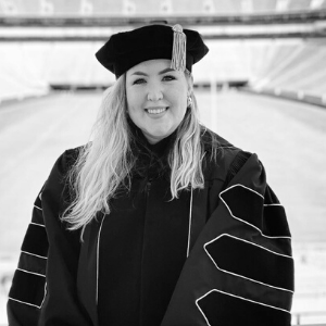 Lindsey Antonini in graduating cap and gown in front of Sanford stadium