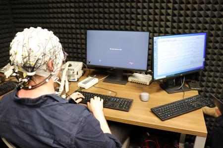 Dr. Chacón measures his brain data while viewing short sentences on a screen.
